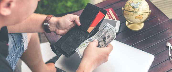 A homeowner counting cash out of a wallet at an outdoor table